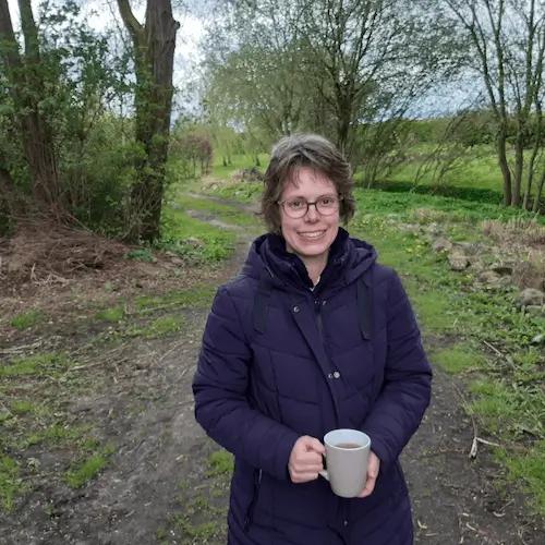 Monique Hiddink, energetisch burn-out coach Monique Hiddink energetisch burn-out coach buiten genieten met een kopje thee in haar handen