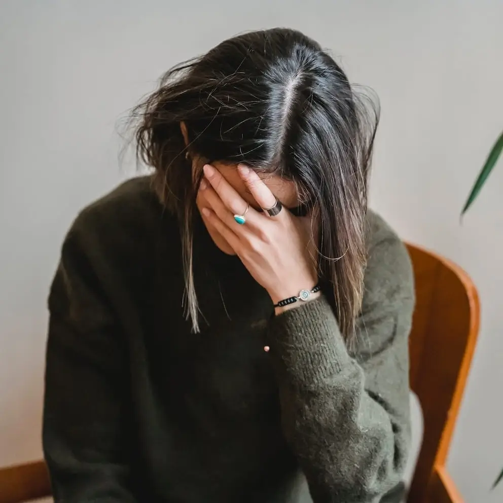 vrouw-weinig-energie-zoekt-oefening-om-meer-energie-te-krijgen Vermoeide vrouw met weinig energie houdt haar hoofd vast en zoekt een effectieve oefening om snel meer energie te krijgen